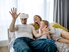 couple-lying-down-with-their-child-watching-something-with-virtual-reality-headset